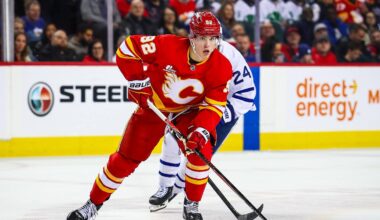 Feb 2, 2026; Calgary, Alberta, CAN; Calgary Flames right wing Matvei Gridin (92) controls the puck against Toronto Maple Leafs center Scott Laughton (24) during the second period at Scotiabank Saddledome. Mandatory Credit: Sergei Belski-Imagn Images