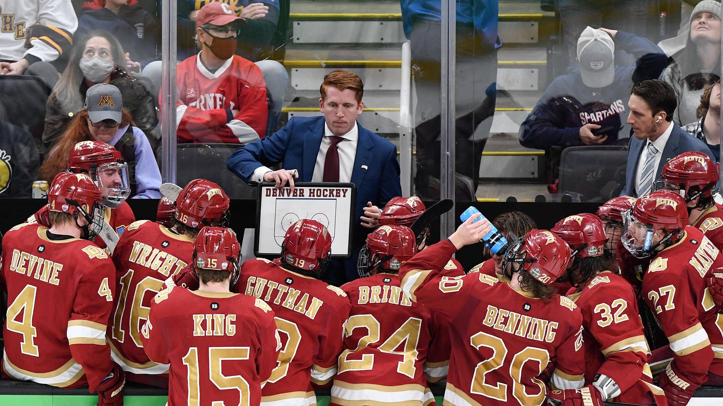 Apr 9, 2022; Boston, MA, USA; Denver Pioneers head coach David Carle talks with his team during a timeout during the third period of the 2022 Frozen Four college ice hockey national championship game against the Minnesota State Mavericks at TD Garden. Mandatory Credit: Brian Fluharty-Imagn Images