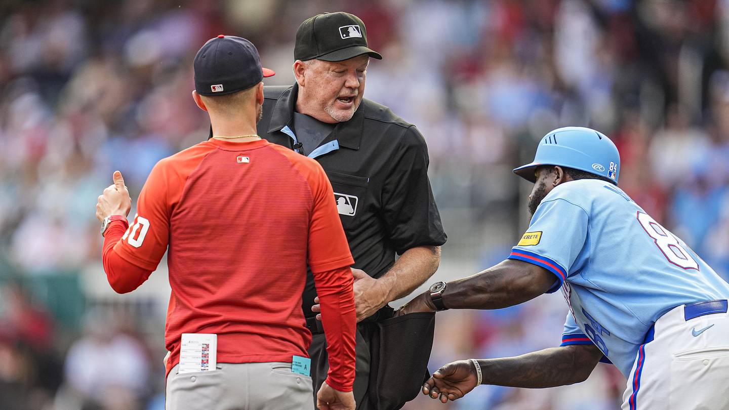 May 23, 2026; Cumberland, Georgia, USA; Atlanta Braves third base coach Tommy Watkins (84) tries to get a ball from umpire John Libka (84) while a discussion about a call takes place with Washington Nationals manager Blake Butera (10) during the seventh inning at Truist Park. Mandatory Credit: Dale Zanine-Imagn Images