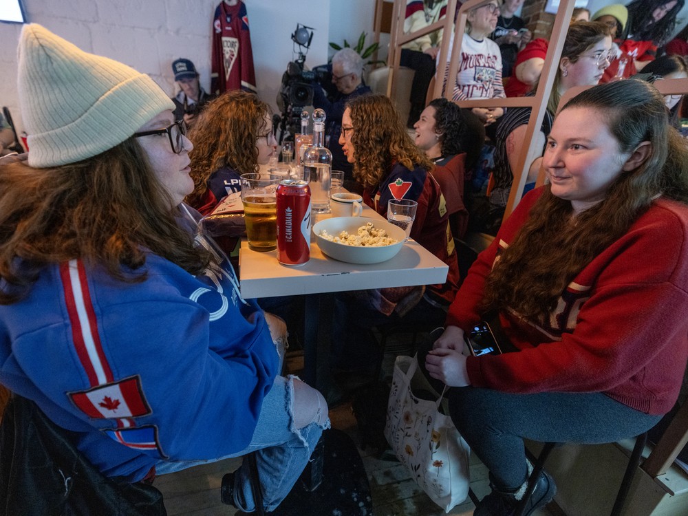 Women sit at a table in a busy bar