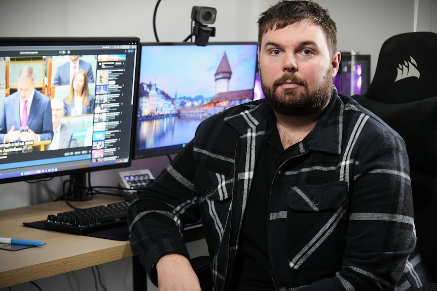 Daniel sits in front of computer screens