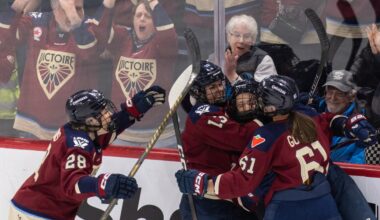 Montreal Victoire players embrace in celebration on the ice.