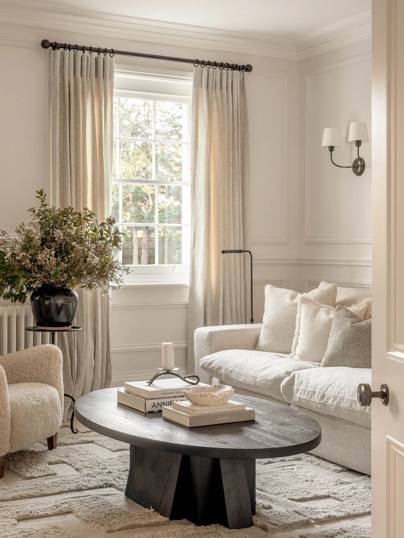 A bespoke home bar by Katharine Pooley with Calacatta Oro marble top, two light-colored armchairs, and a small round table with coffee cups.