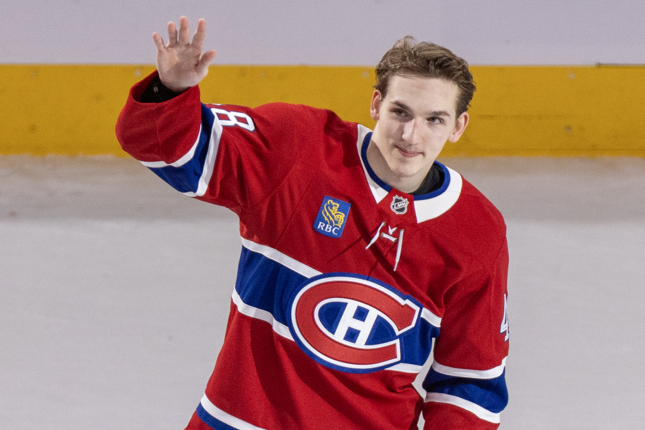 Montreal Canadiens' Lane Hutson waves from the ice.
