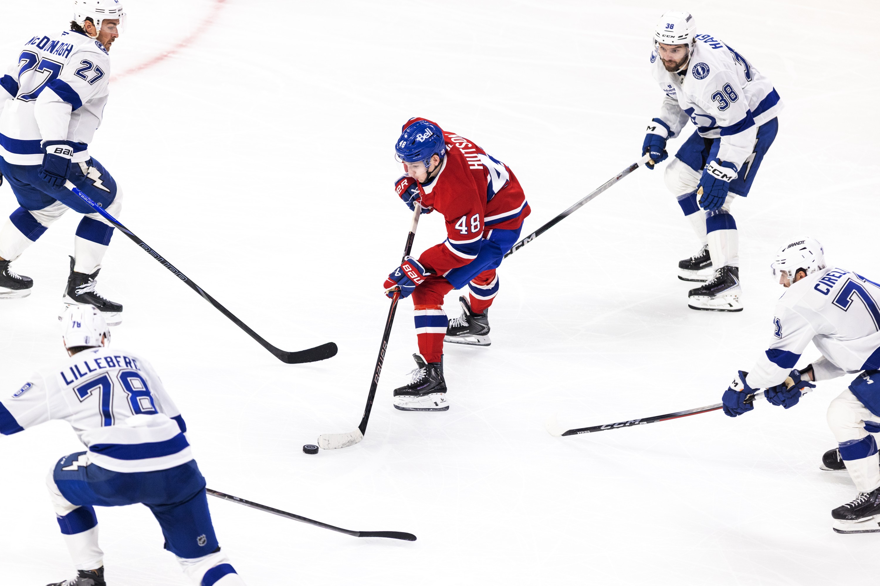 Hockey player is surrounded by four opponents.