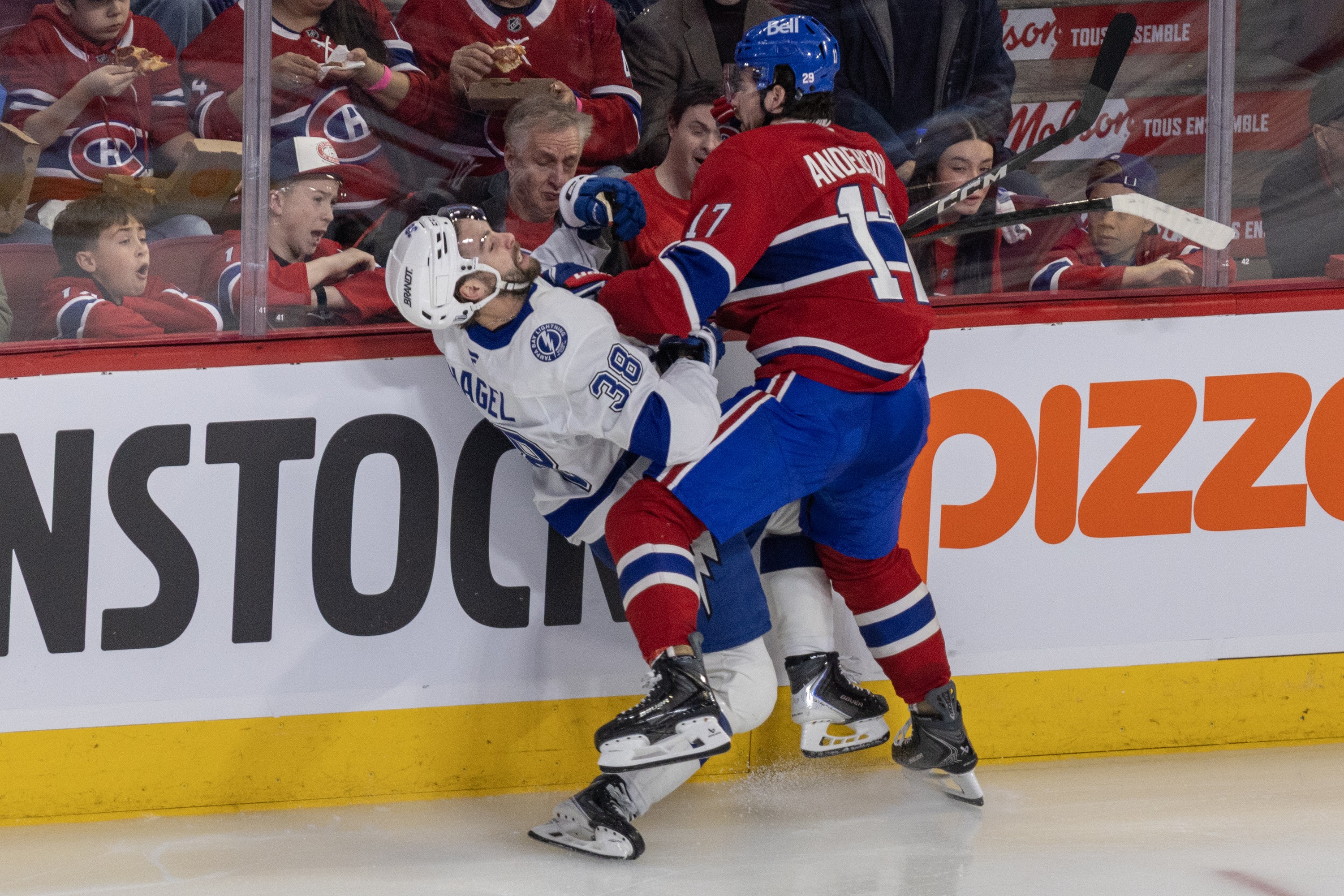 Canadiens' Josh Anderson slams  Lightning's Brandon Hagel into the boards, bending him backward.