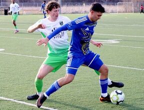 Two soccer players battle for a ball