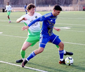 Two soccer players battle for a ball