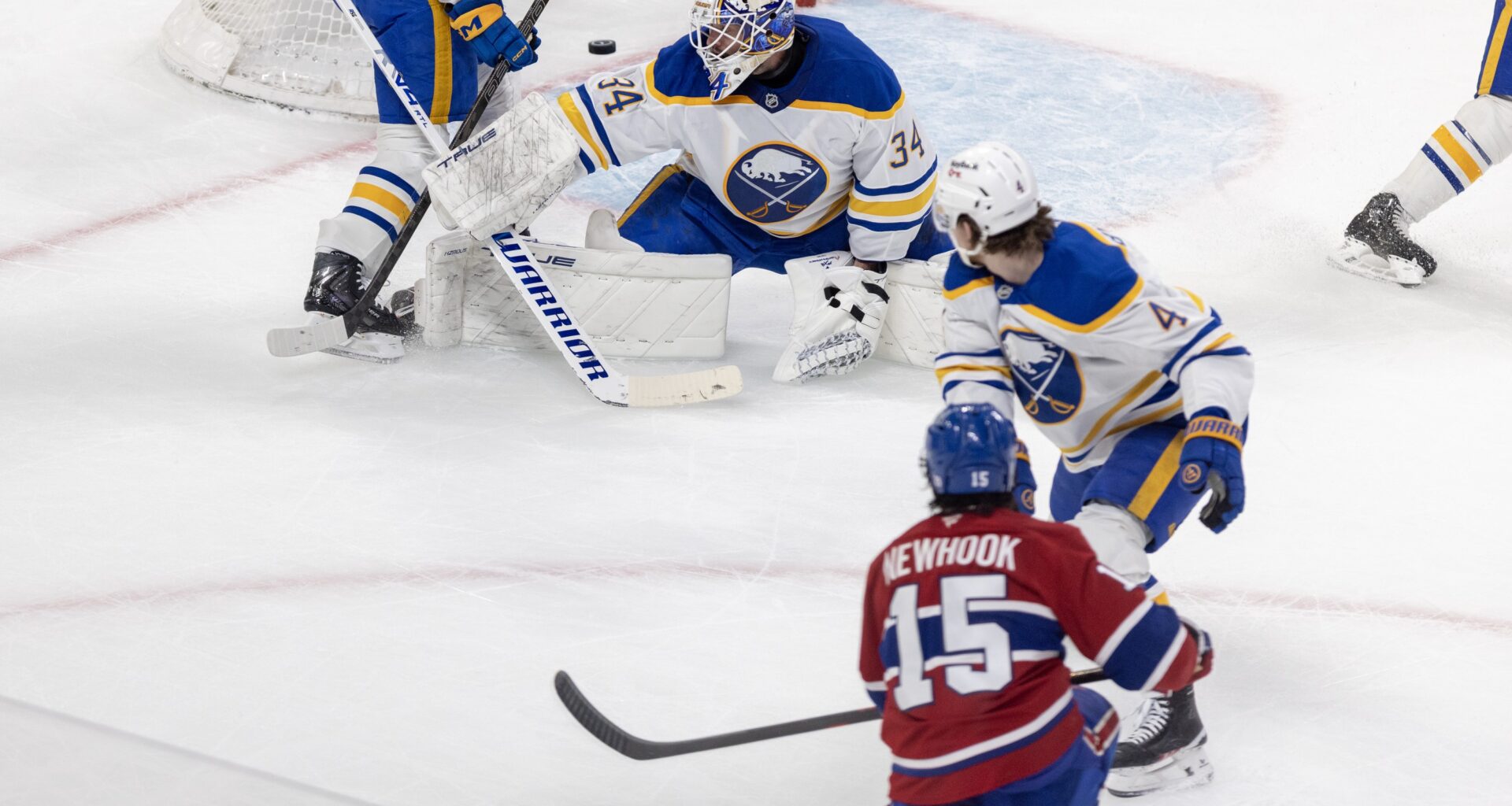 Montreal Canadiens' Alex Newhook shoots the puck past Buffalo Sabres goalie Alex Lyon and defenceman Bowen Byram.