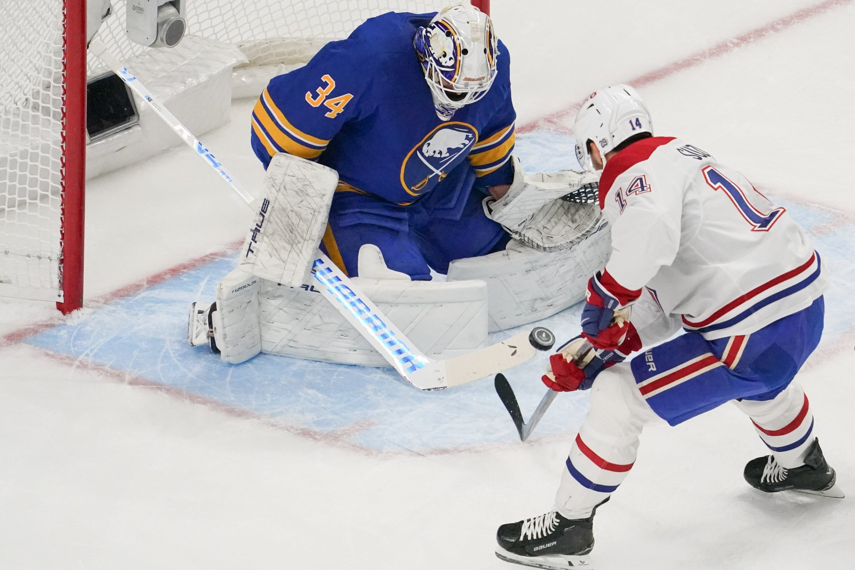 Hockey goaltender makes a stop on an opponent close in.