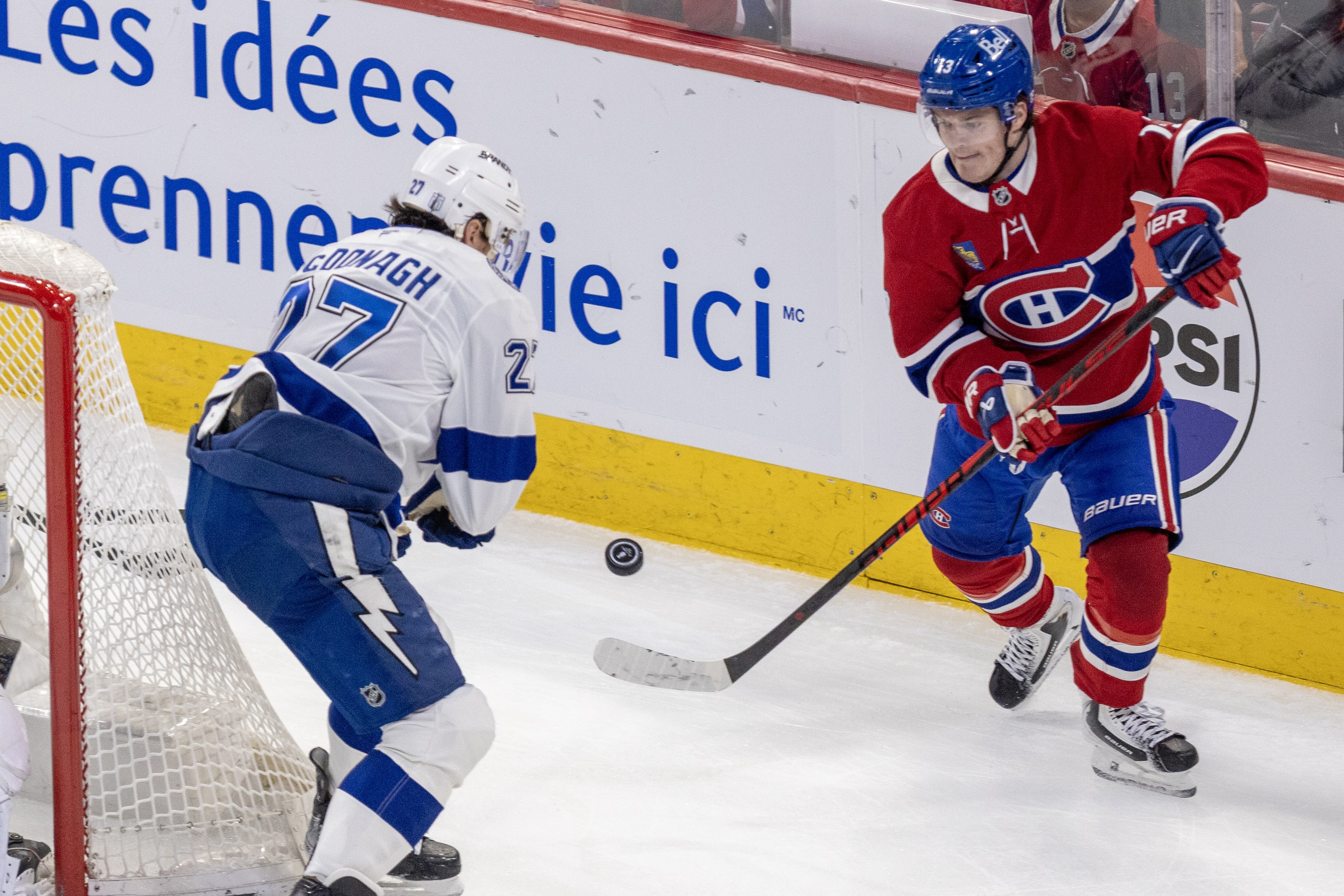 Canadiens winger Cole Caufield passes the puck past Tampa Bay Lightning defenceman Darren Raddysh during the second period of Game 4 at the Bell Centre on April 26.