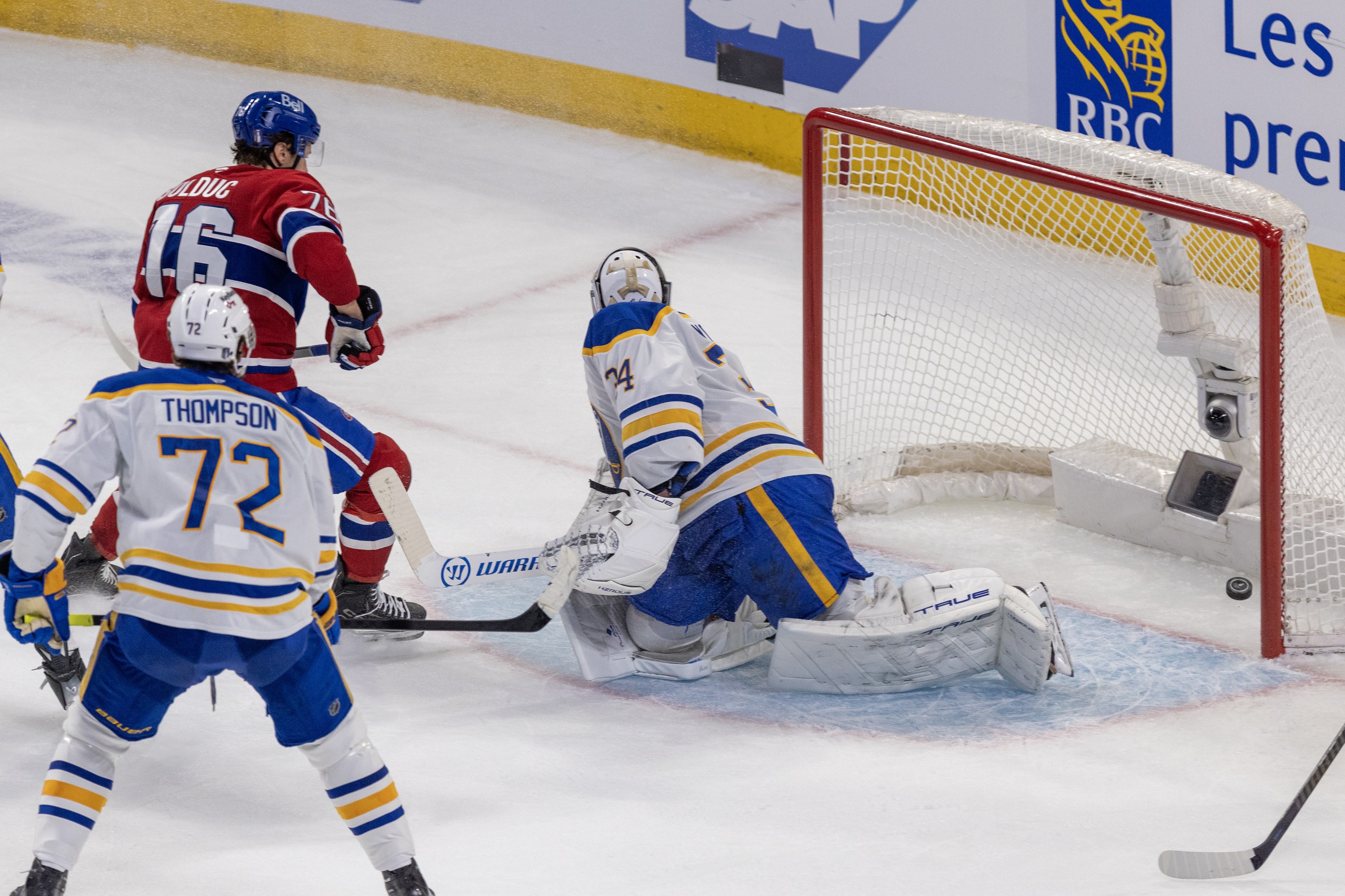 Montreal Canadiens' Zachary Bolduc scores a goal against Buffalo Sabres goalie Alex Lyon as Tage Thompson watches.