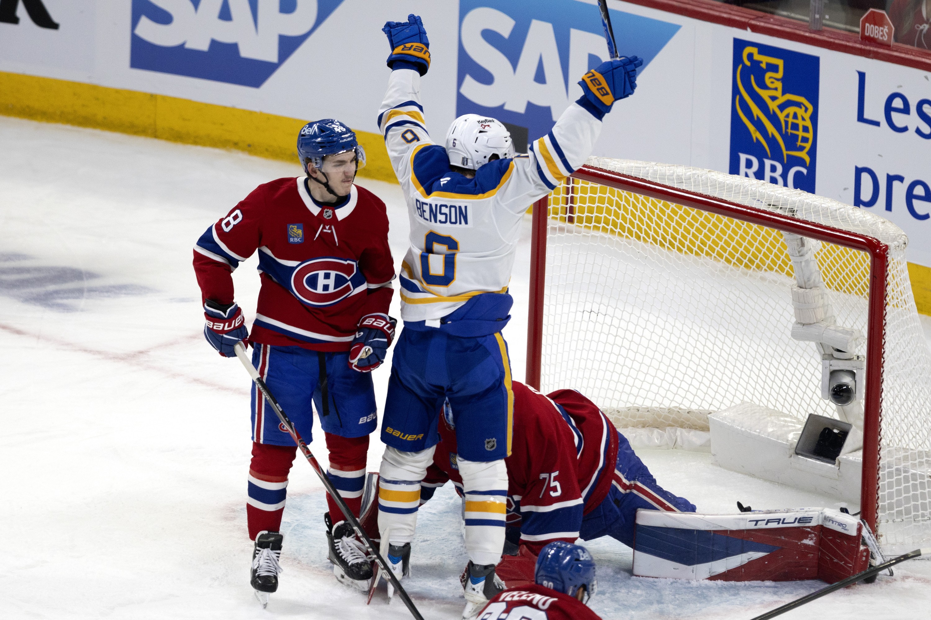 Canadiens' Lane Hutson (48) watches Buffalo Sabres' Zach Benson (6) celebrate in front of the Canadiens' net.