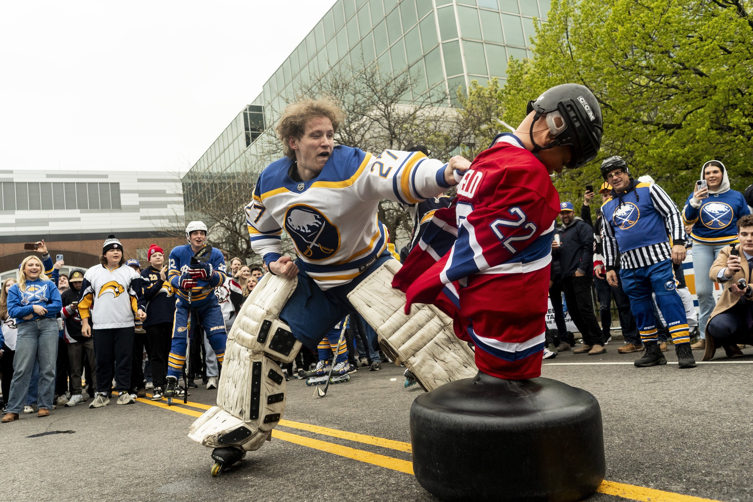 Man in Sabres gear tackling dummy in Canadiens gear