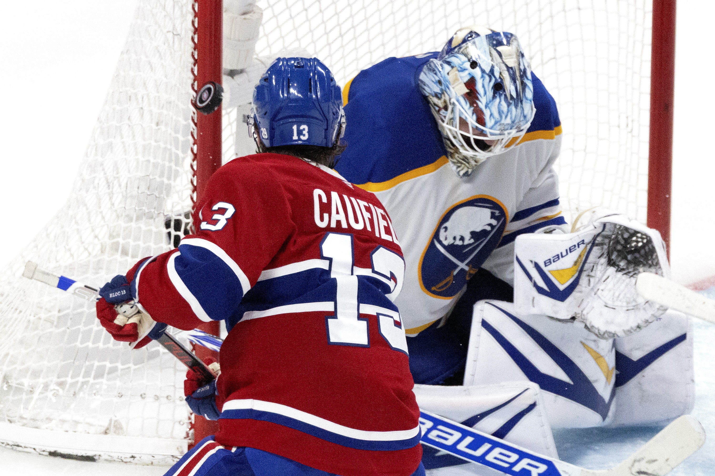 Buffalo Sabres goaltender Ukko-Pekka Luukkonen makes a save as Montreal Canadiens right wing Cole Caufield looks for a rebound.
