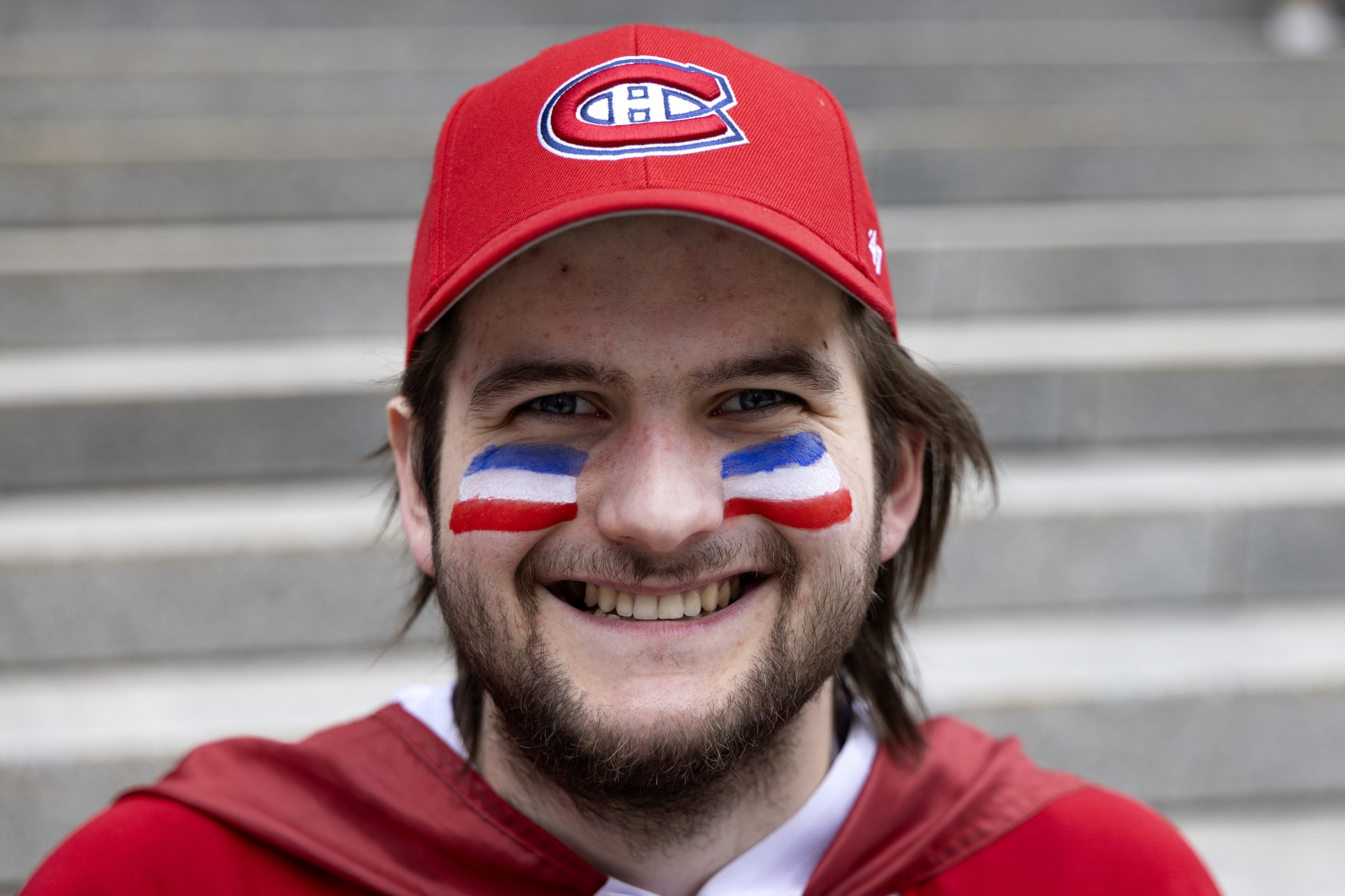 A Canadiens fan with his face painted in blue, white and red. 