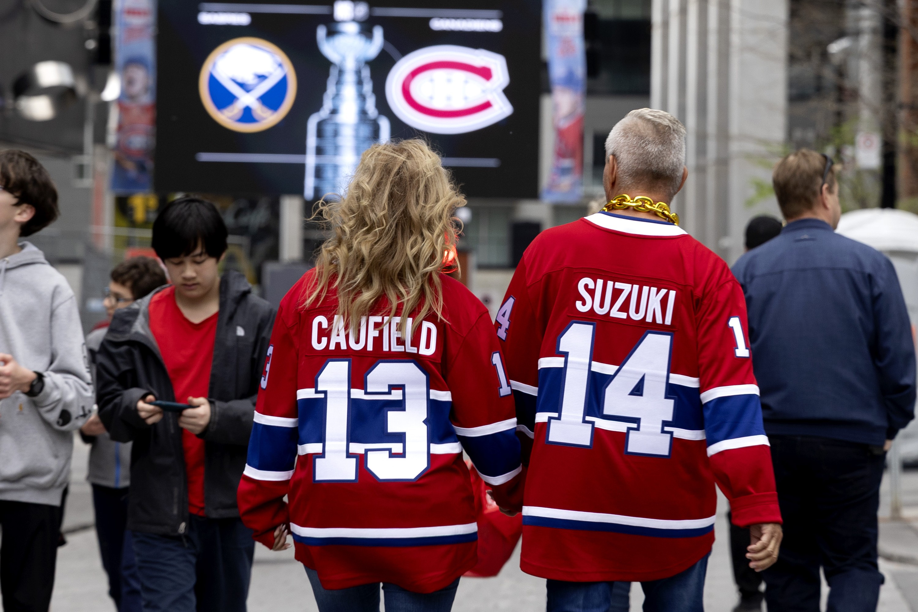 Canadiens fans wearing team jerseys walk around the Bell Centre before the start of Game 6.