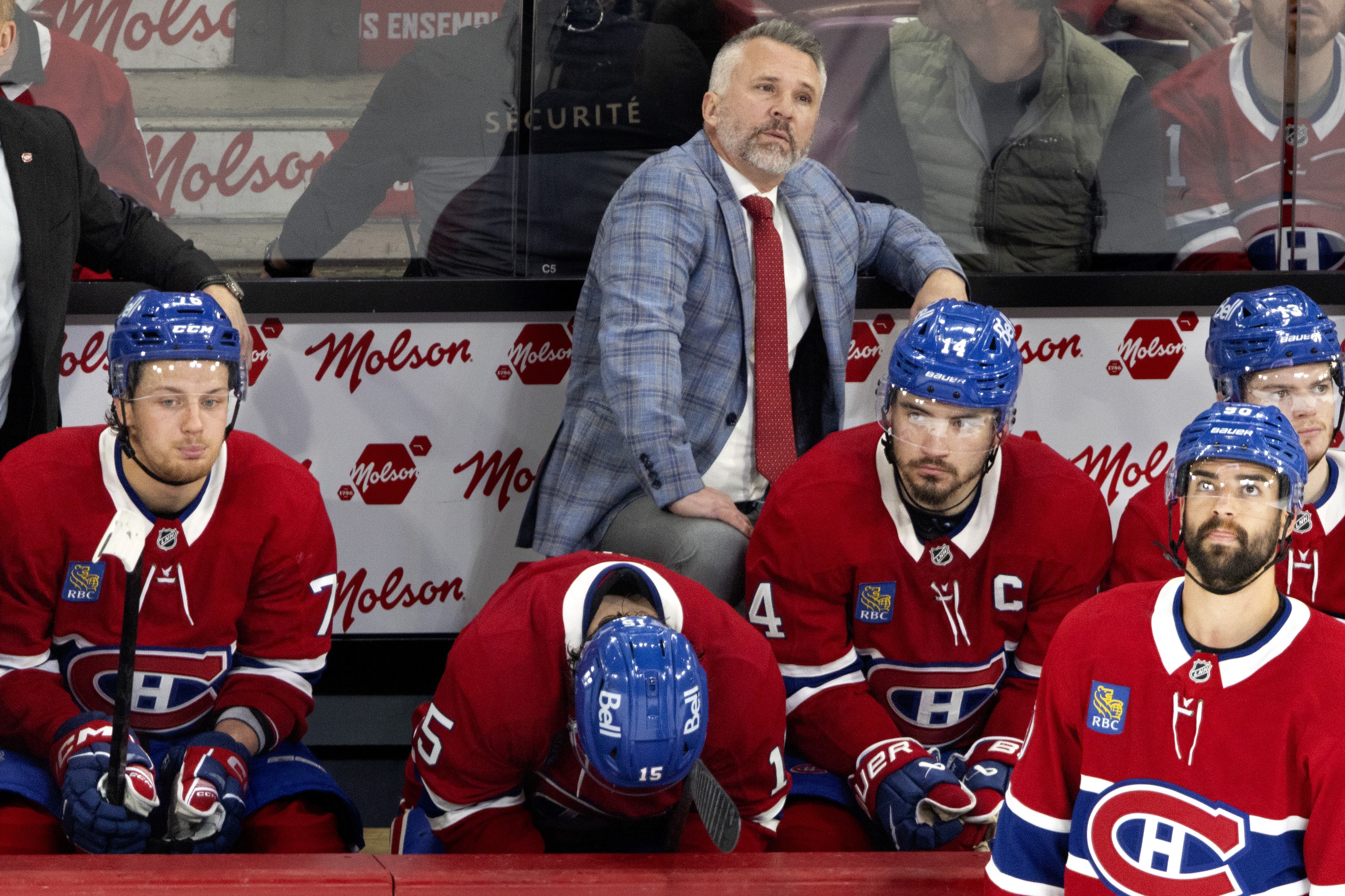 Hockey player on the bench and the head coach are dejected after losing a game.