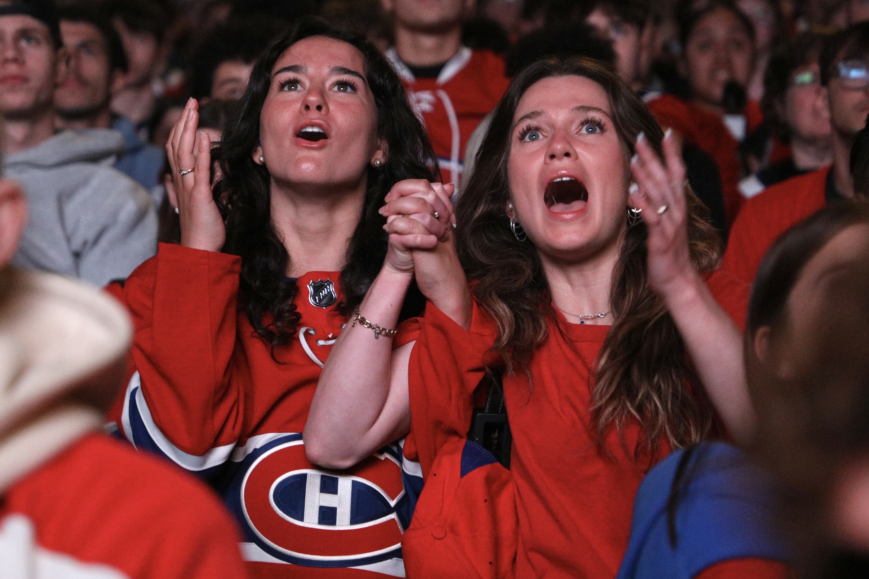 Two female Habs fans hold hands and look on in shock as Montreal gives up a goal.
