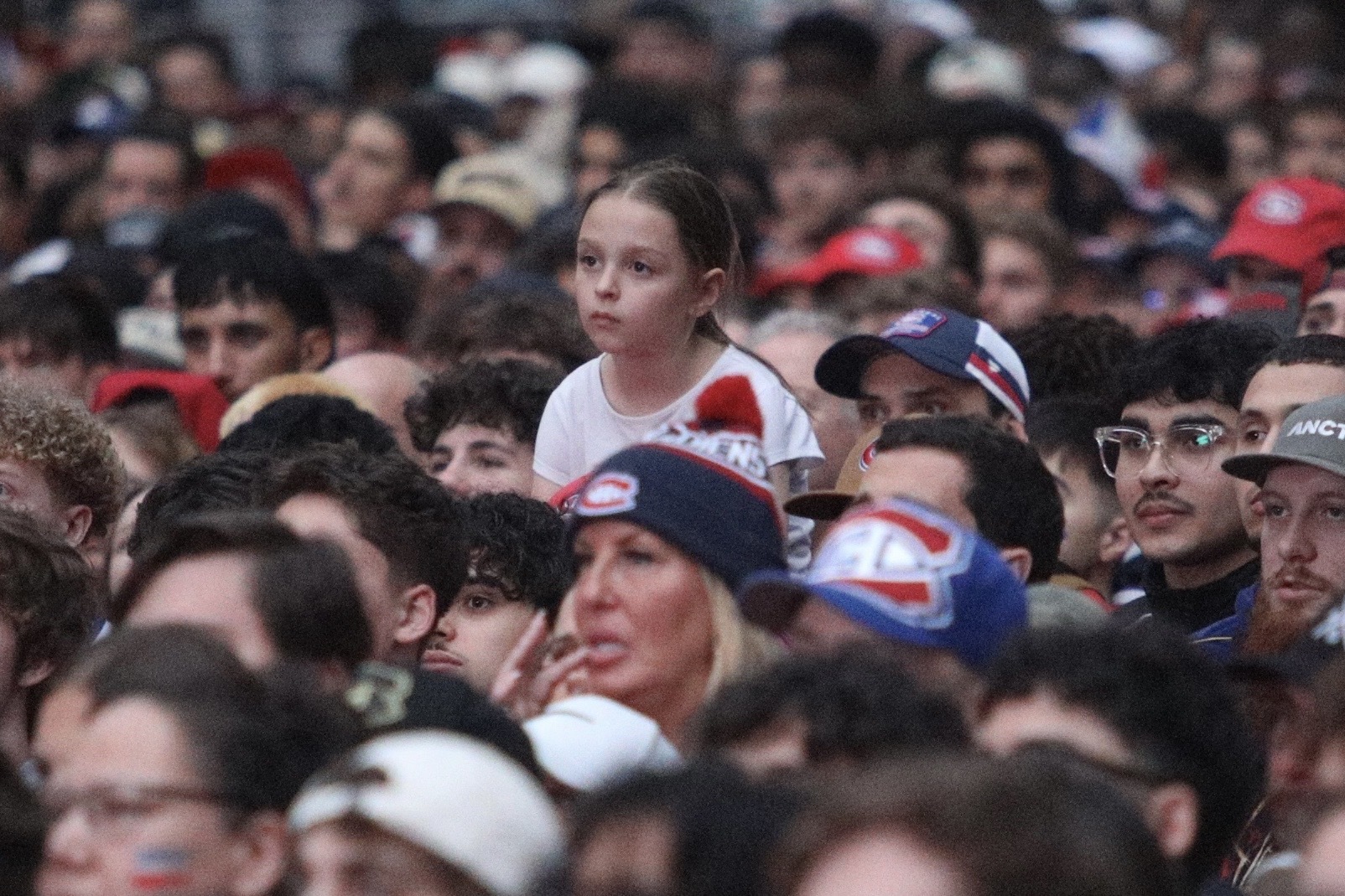 Partial view of large crown outside the Bell Centre, with one young girl's face clearly showing her disappointment.