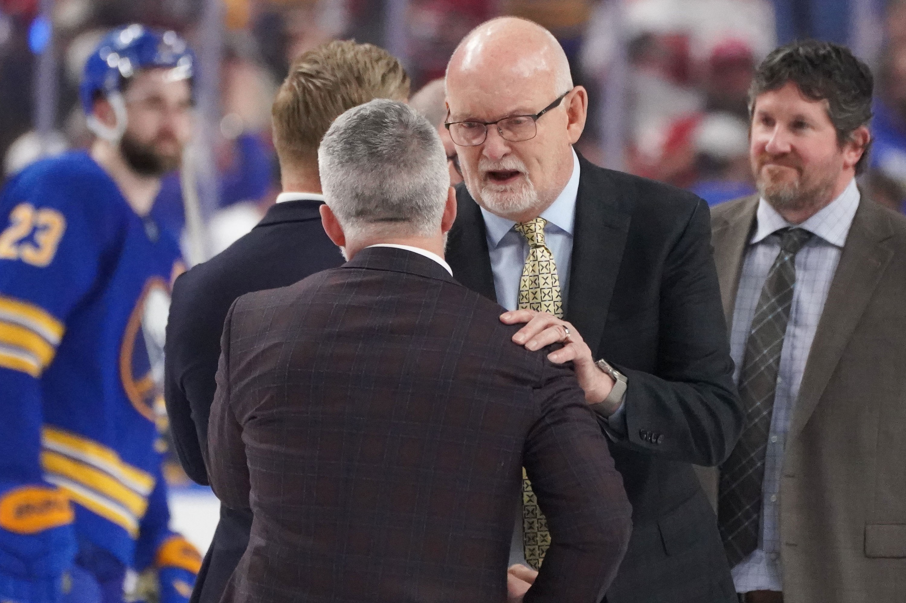 Martin St. Louis and Lindy Ruff shake hands on the ice.