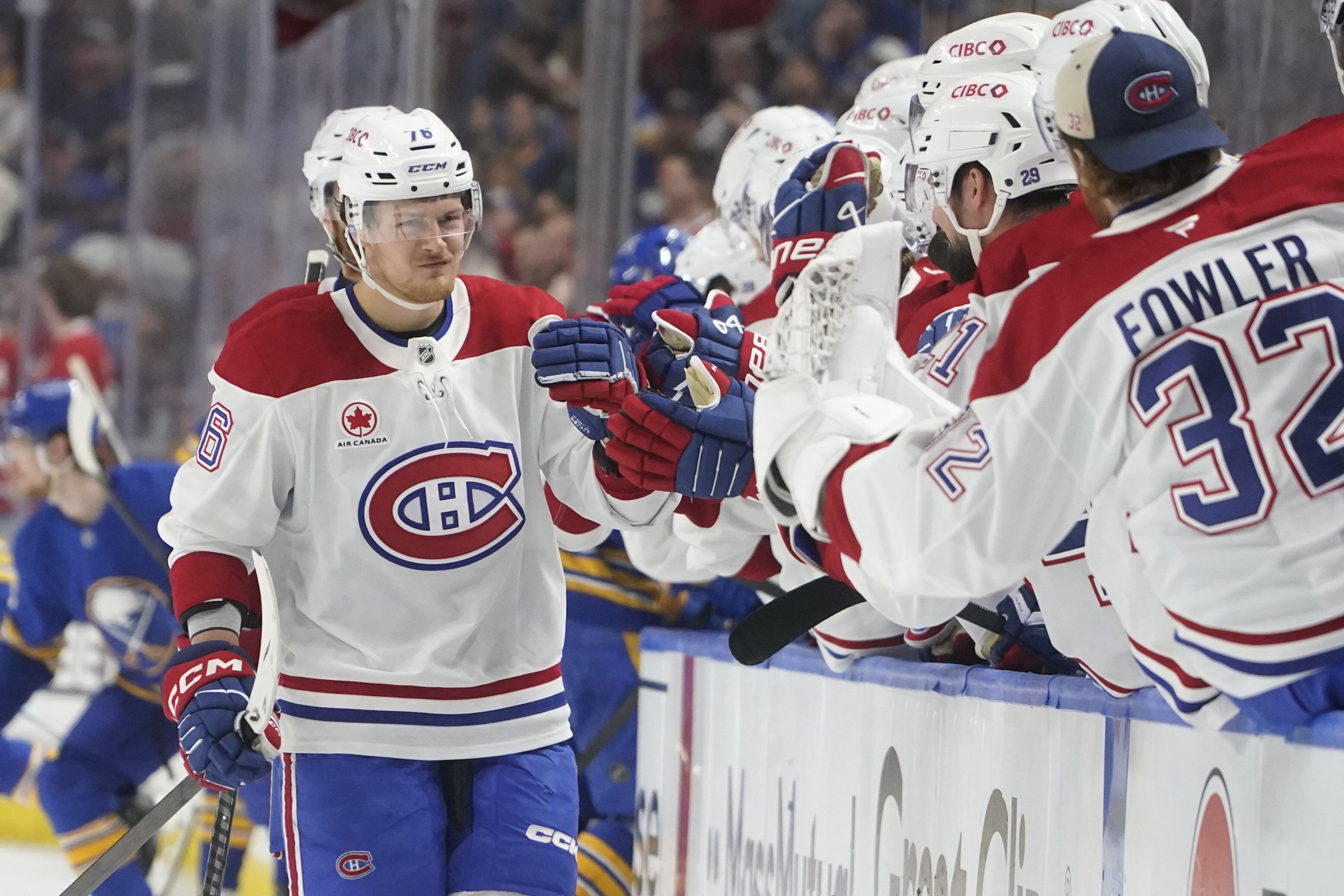 Canadiens' Zachary Bolduc fist-bumps teammates as he skates by the bench