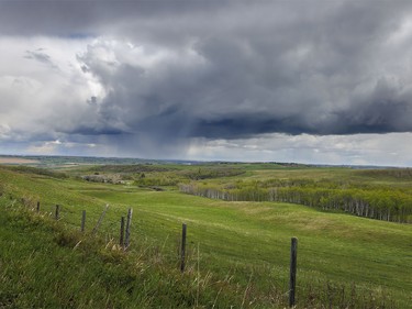 Rain falls from storm clouds southwest of Calgary, Ab., on Wednesday, May 20, 2026.