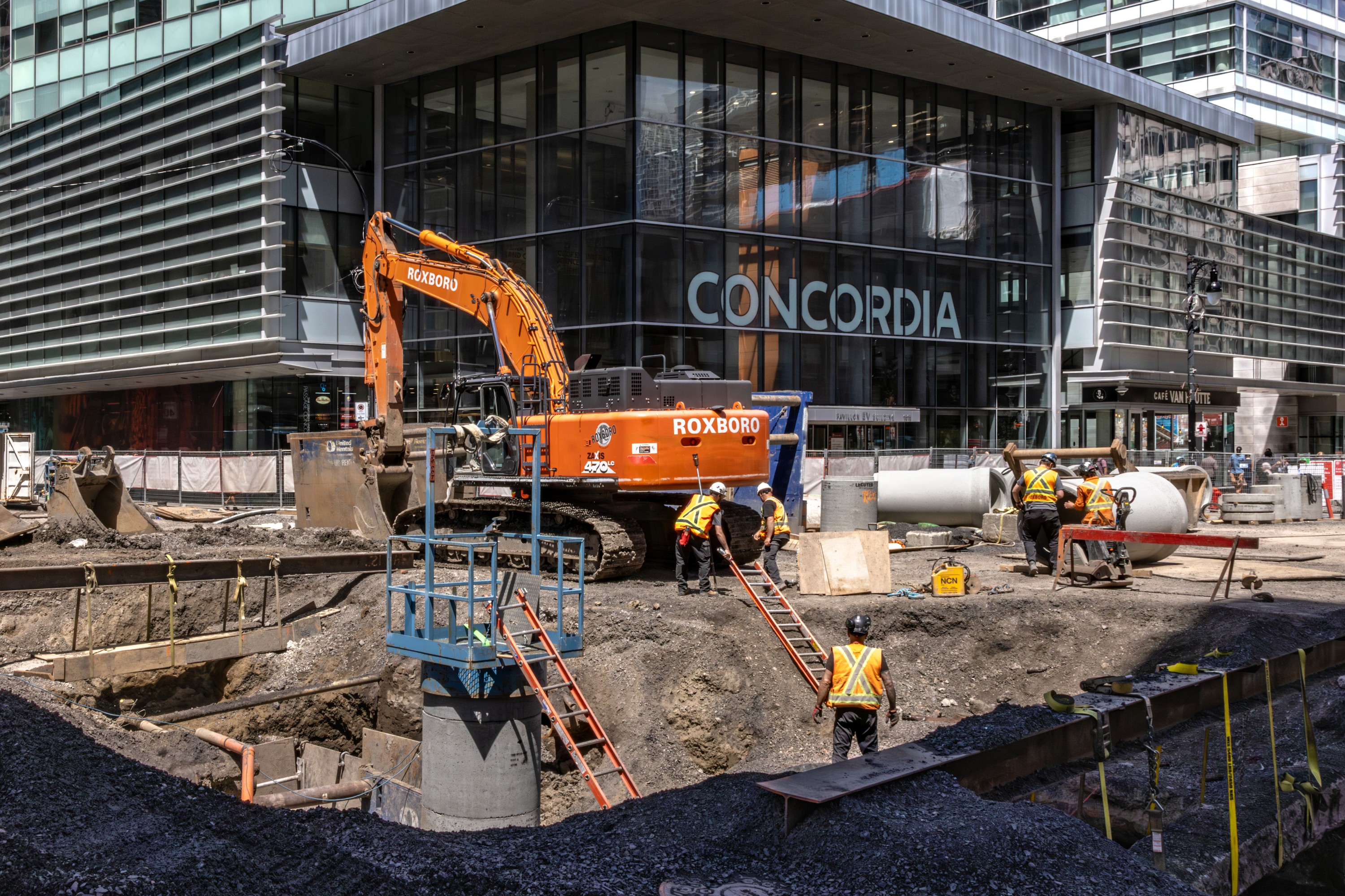 A downtown street intersection is turned into a pit with construction.