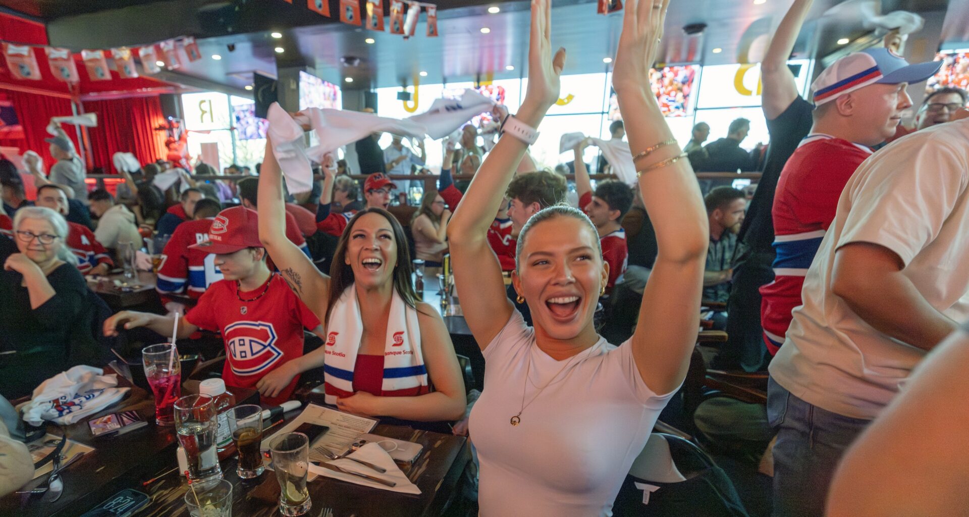 Canadiens fans Madison McLellan, right, and Melissa Ayotte celebrate a Habs goal while watching the Game 1 of Eastern Conference final against the Carolina Hurricanes at Brasserie des Rapides in LaSalle on Thursday night.