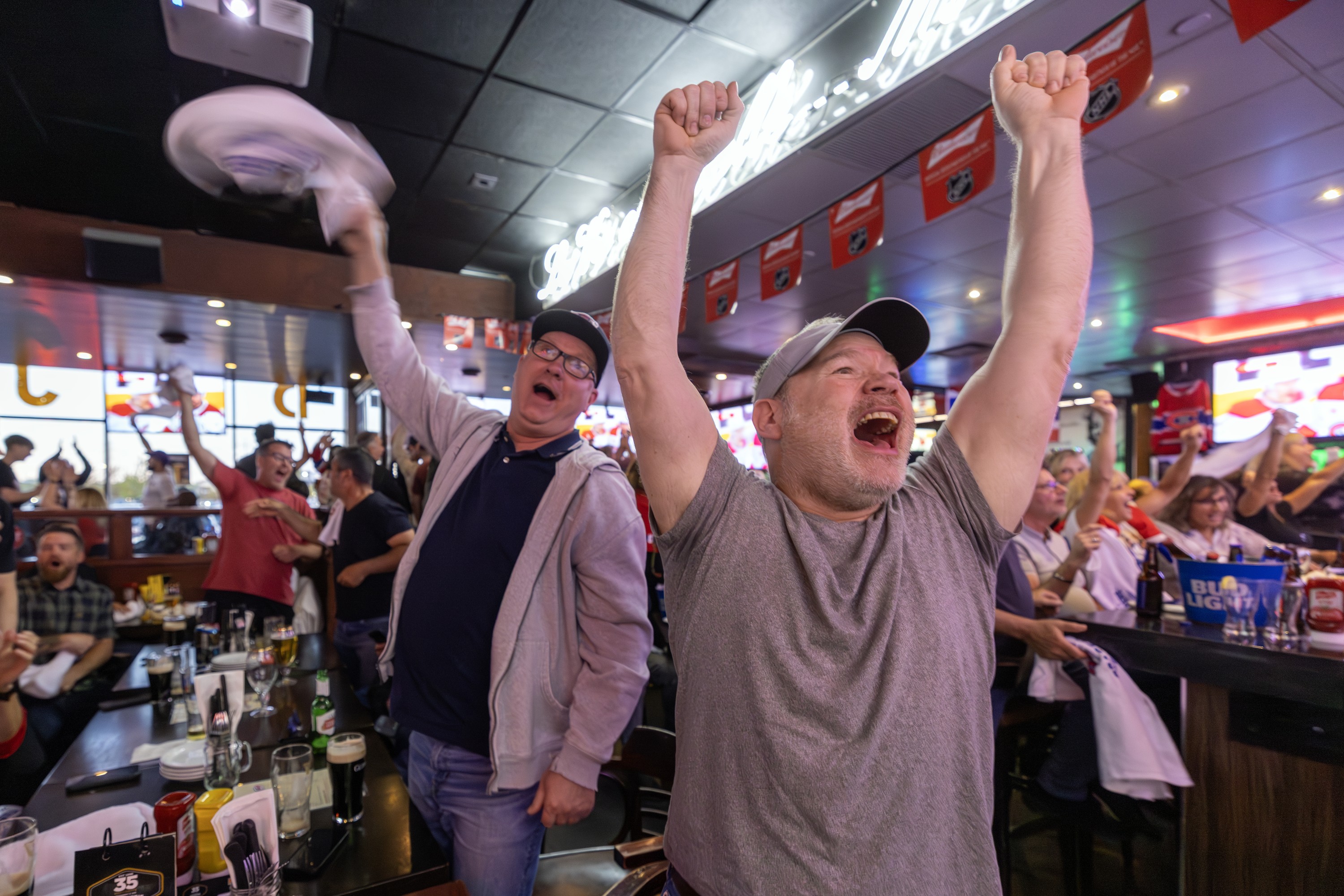 Canadiens fans Derek Clarke, right, and Blaine Larsen celebrate a Habs goal during Game 1 of Eastern Conference final against the Carolina Hurricanes at Brasserie des Rapides in LaSalle on Thursday night.