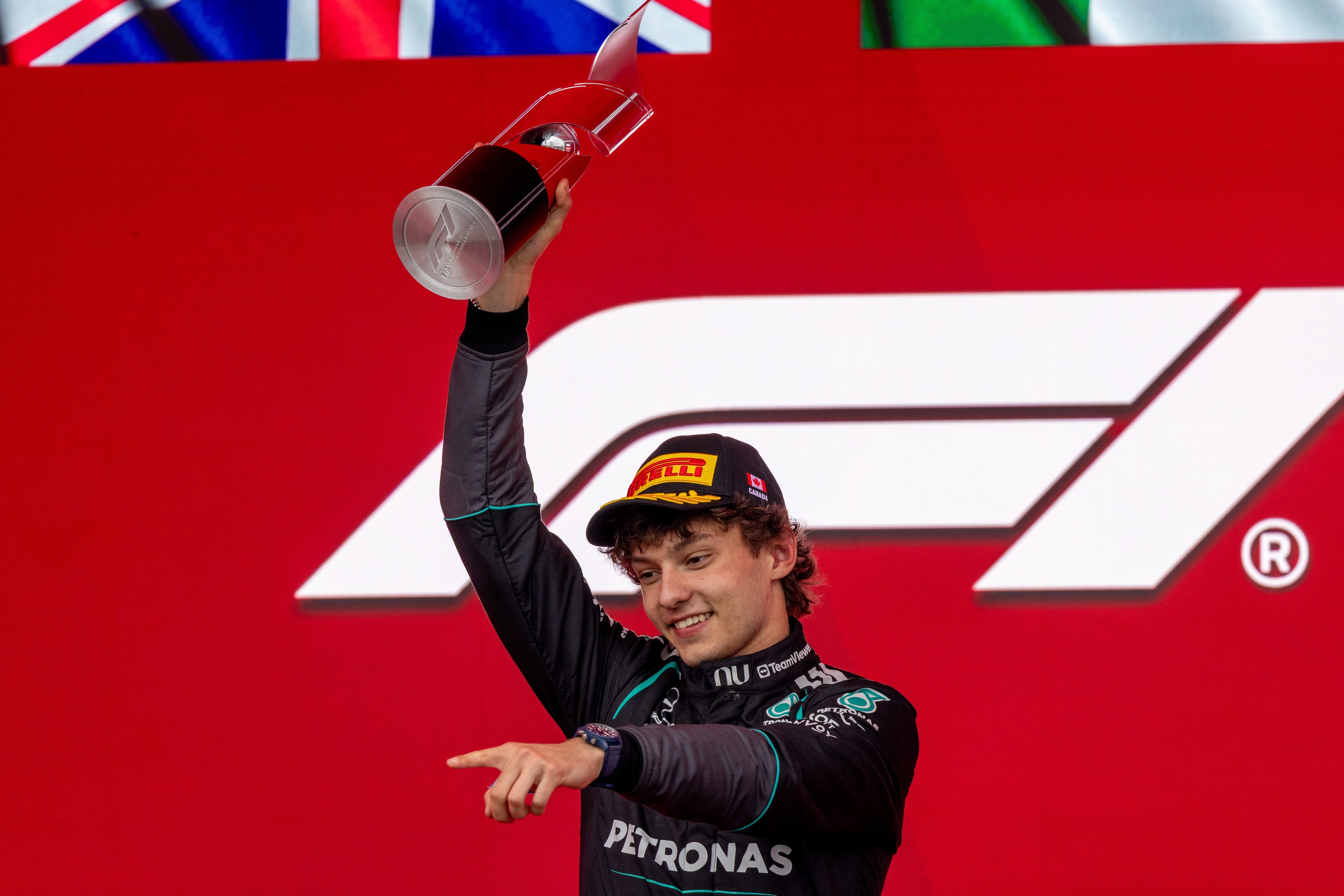 Mercedes driver Kimi Antonelli raises his trophy and points after winning the Canadian Grand Prix.