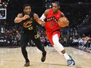 RJ Barrett of the Toronto Raptors drives to the basket against Donovan Mitchell of the Cleveland Cavaliers.