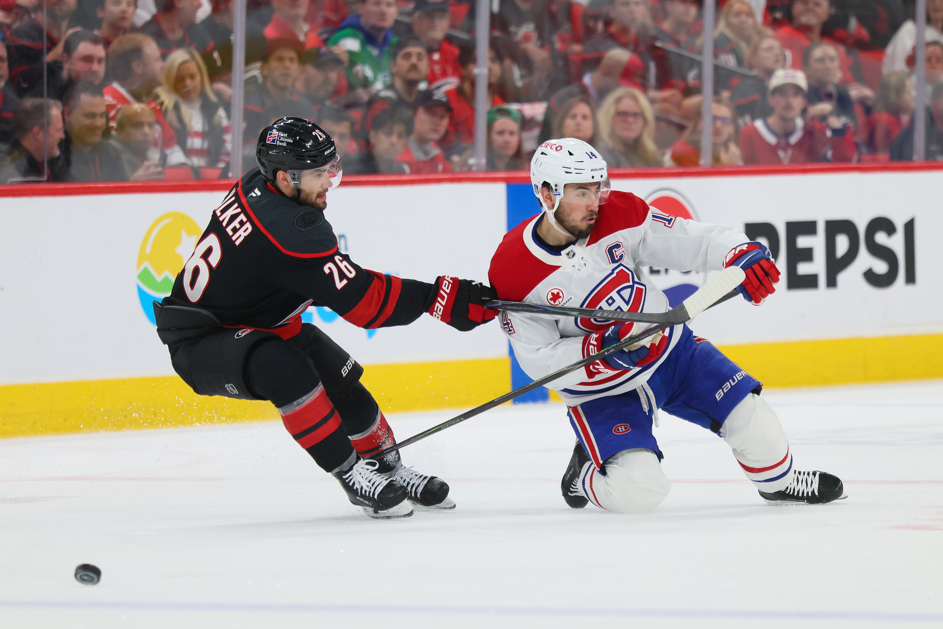 Hurricanes' Sean Walker is all over Canadiens captain Nick Suzuki.