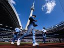 Daulton Varsho, Andres Gimenez and Vladimir Guerrero Jr. of the Toronto Blue Jays come off the field during a game at Rogers Centre last year.