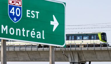 REM train on elevated platform travels by Highway 40 / Montreal sign