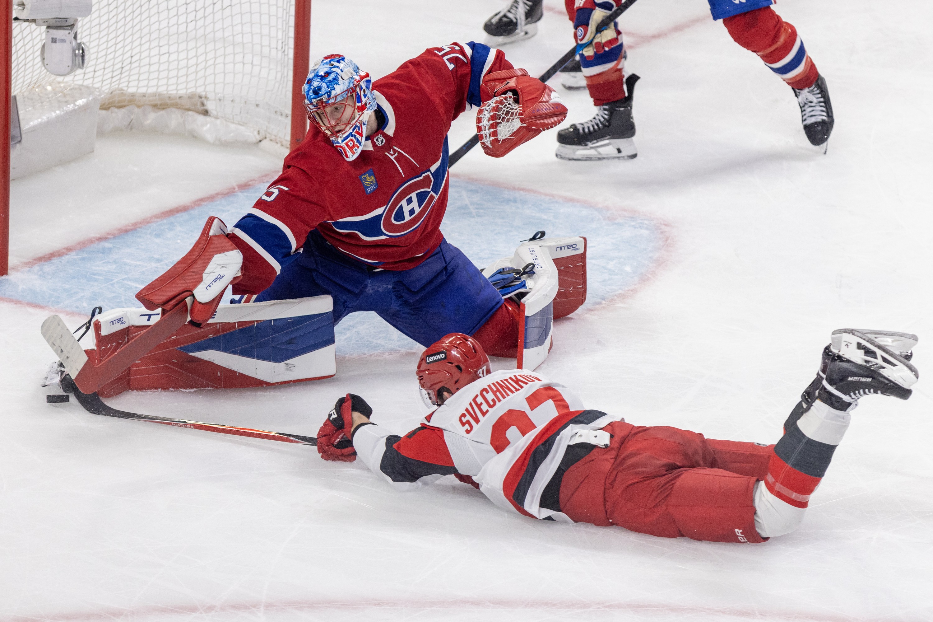 Canadiens' Jakub Dobes makes a save on Carolina Hurricanes' Andrei Svechnikov after he was tripped by Kaiden Guhle during second period of Game 3 in Montreal on Monday.