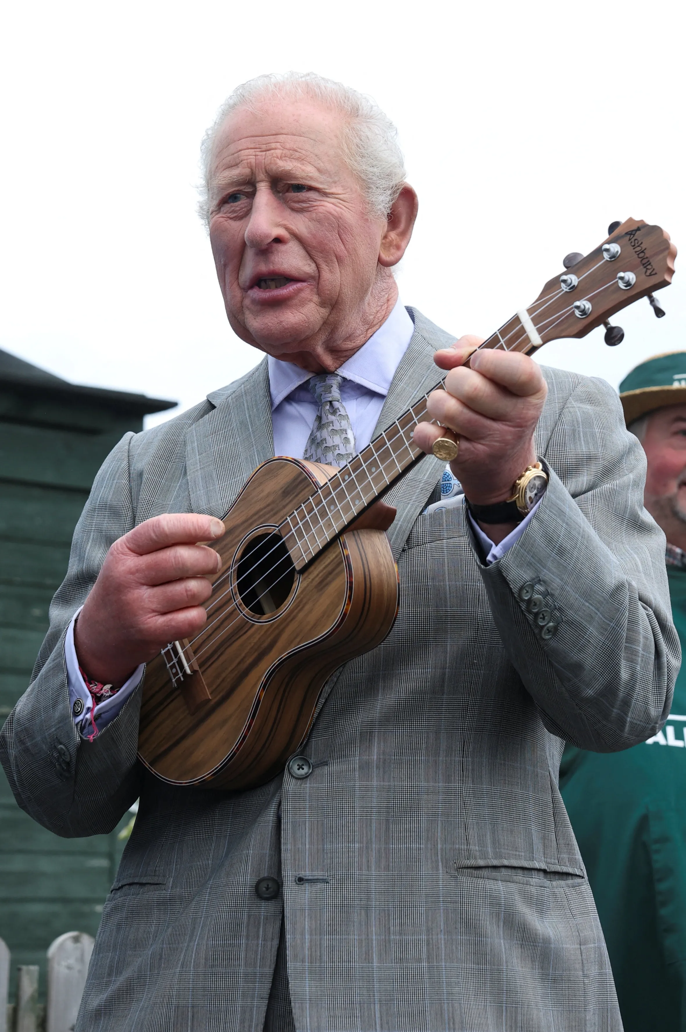 King Charles III plays a ukulele.