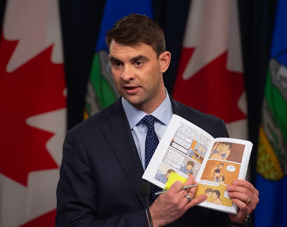 Municipal Affairs Minister Dan Williams holds a graphic novel that he claimed was offensive for a depiction of a sexual act on April 2, 2026. Shaughn Butts/Postmedia