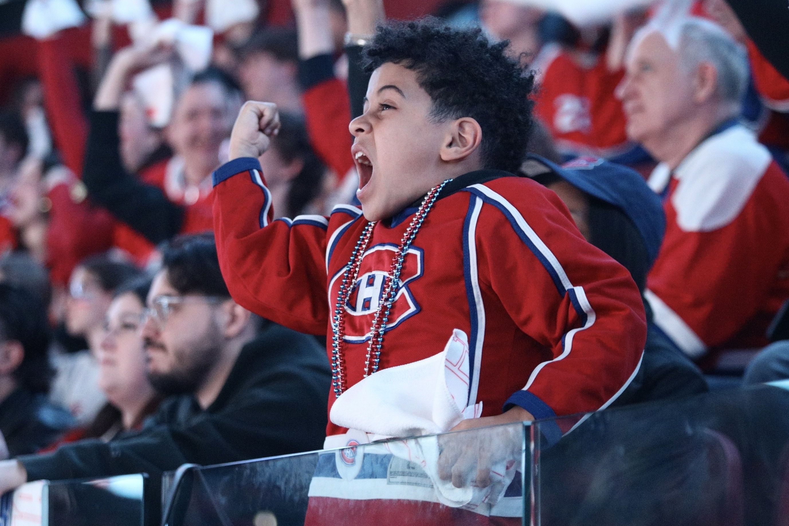 A boy wearing a Canadiens jersey cheers in the stands