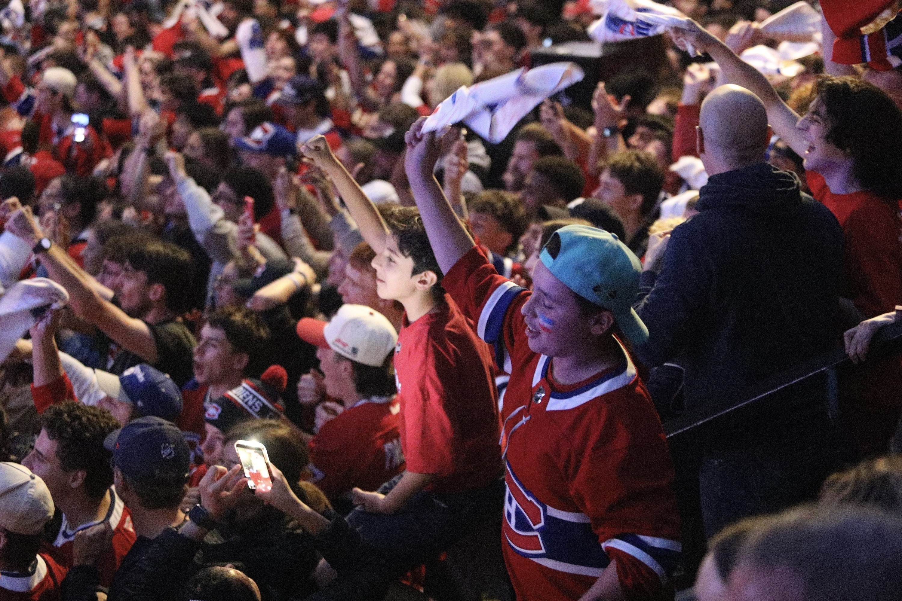 Fans celebrate a Canadiens goal while watching on an outdoor screen during Game 6.