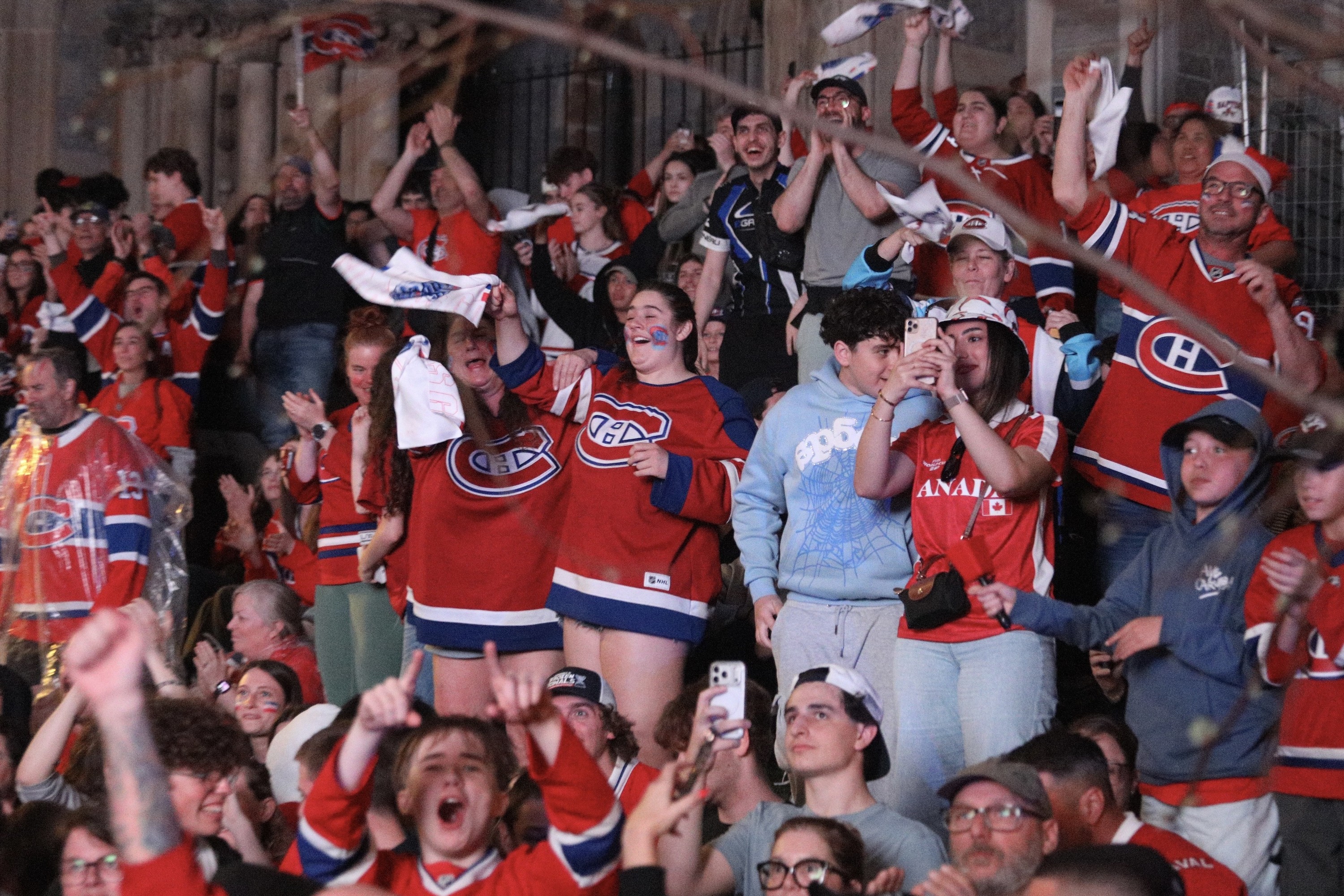 Fans celebrate a Canadiens goal at an outdoor watch party.