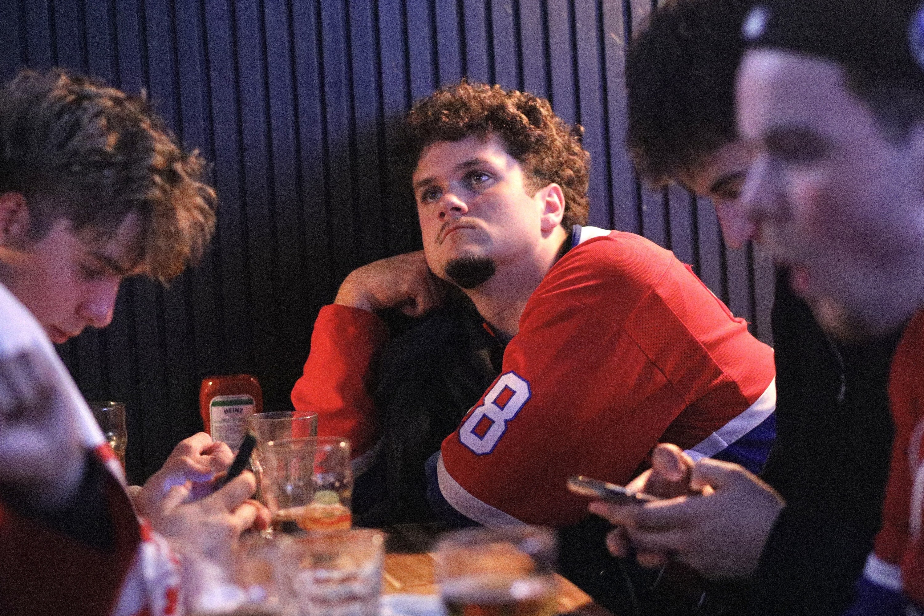Hockey fan is disappointed as he is watching a game at a bar.