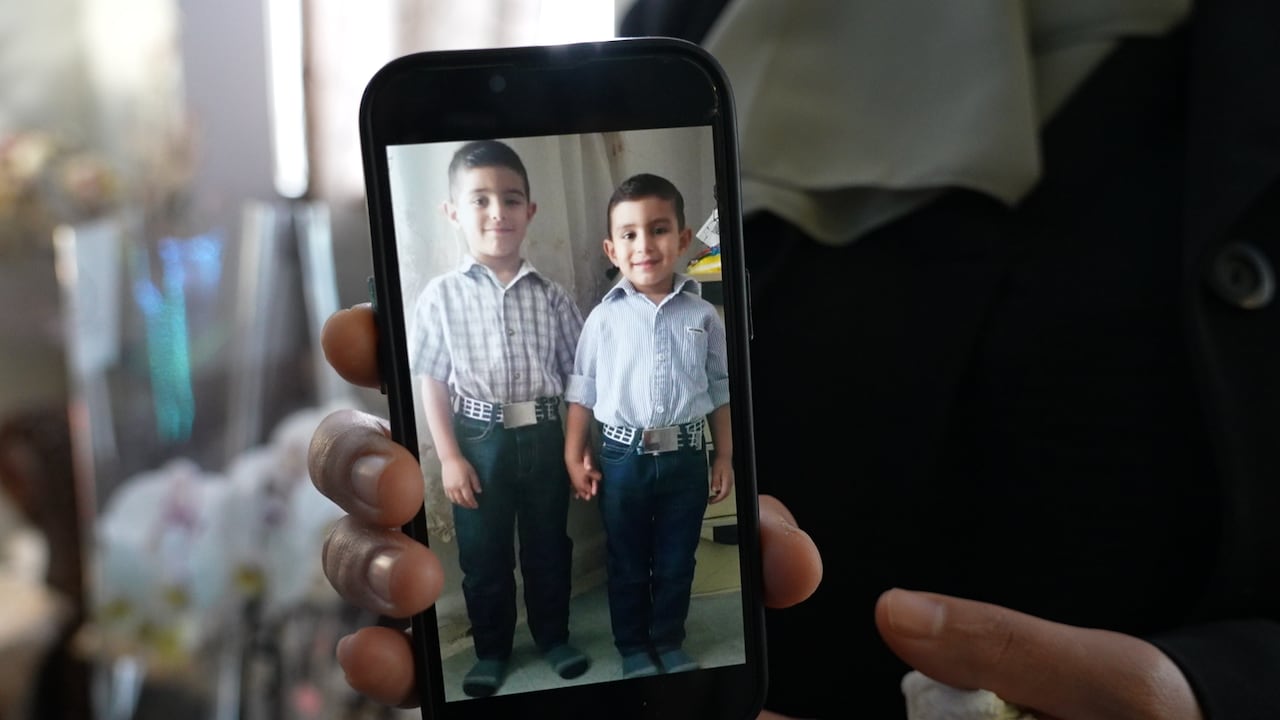 Someone shows a photo on a phone of two young children.