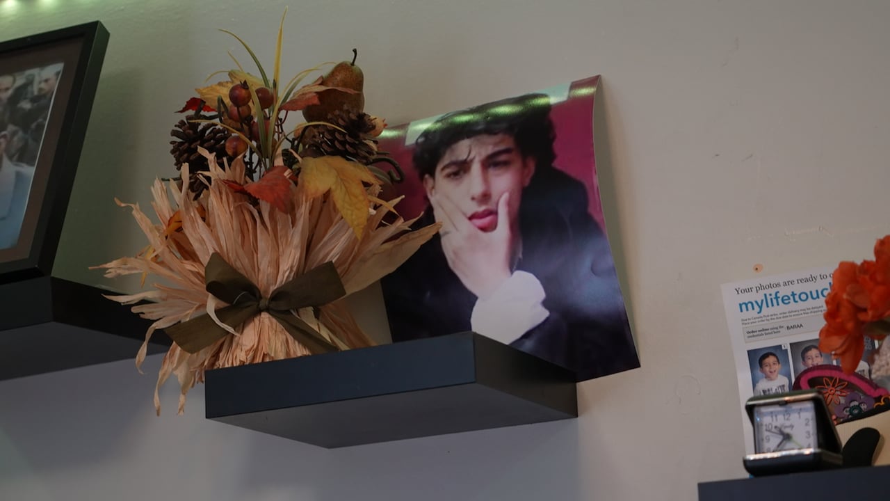 A printed photo of a teen set up on a shelf.