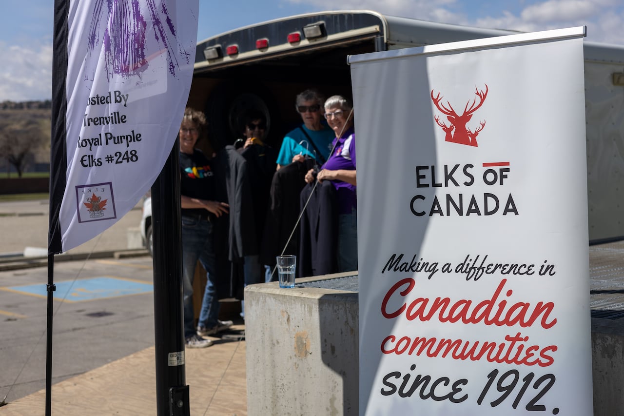 A sign with a group of volunteers in the background.