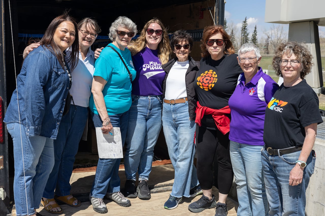 A group of women pose for a photo outdoors.