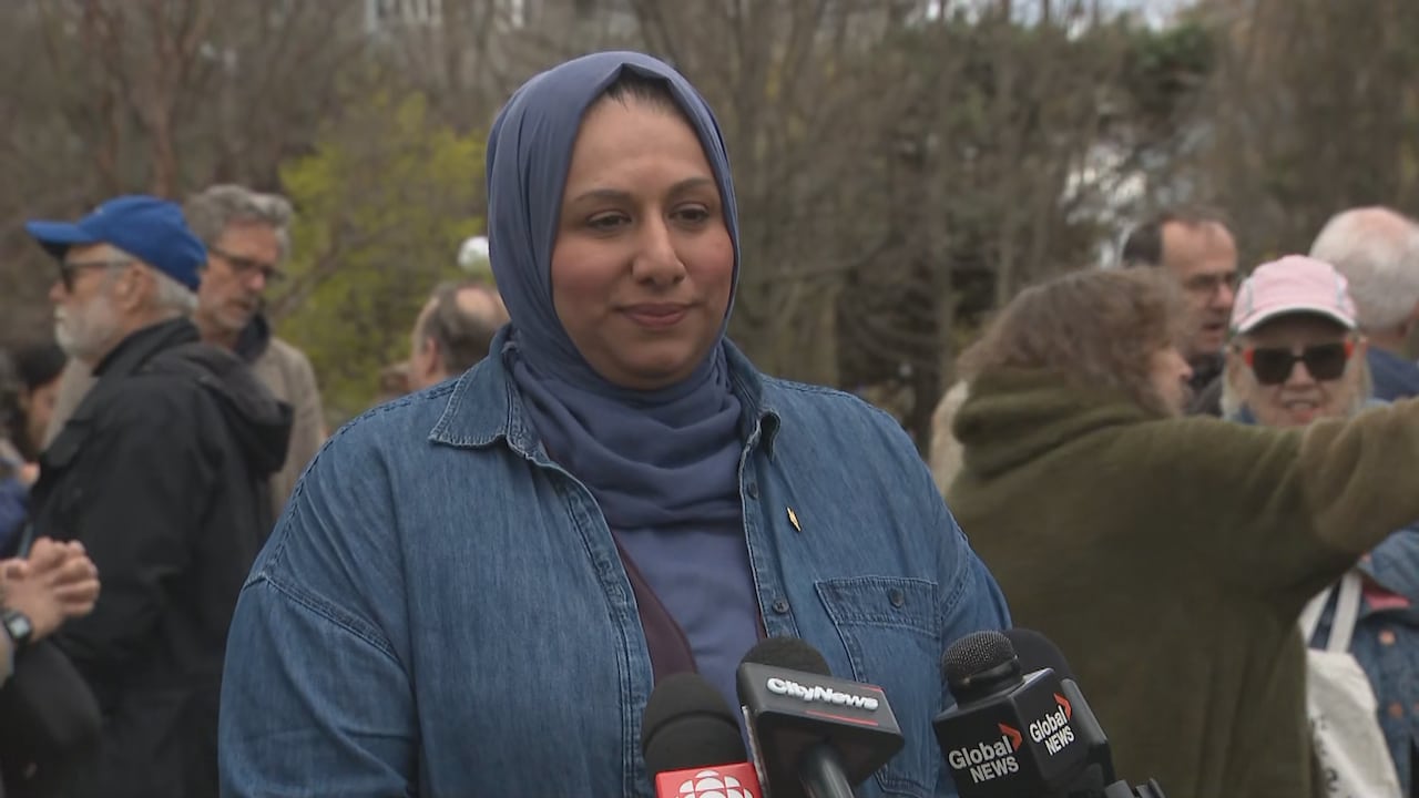 Woman standing in front of microphones, smiling