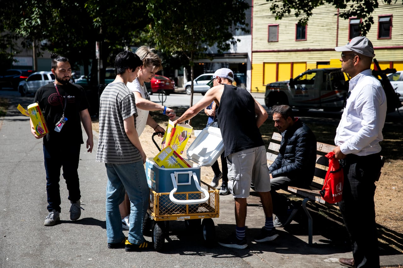 Members of the Powell St Festival Society hand out popsicles on July 18, 2023 to help residents in the Downtown Eastside stay cool.