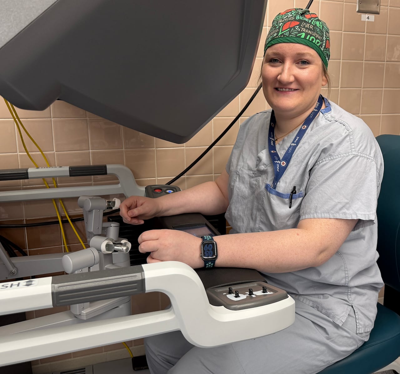 A woman in scrubs operating a machine