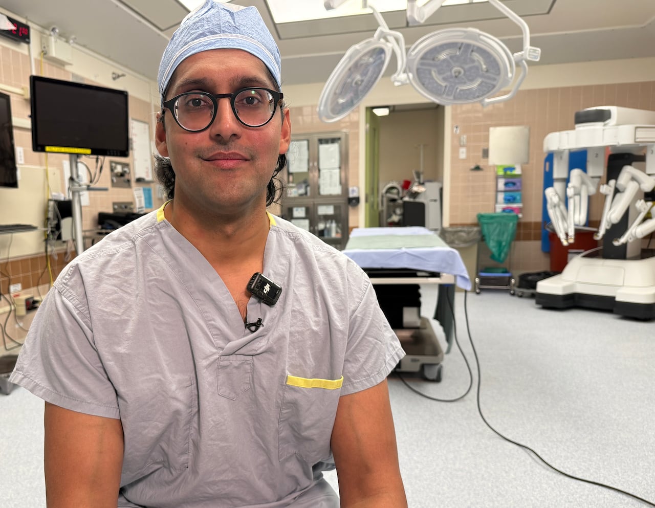 A man in scrubs sits in a hospital operating room.